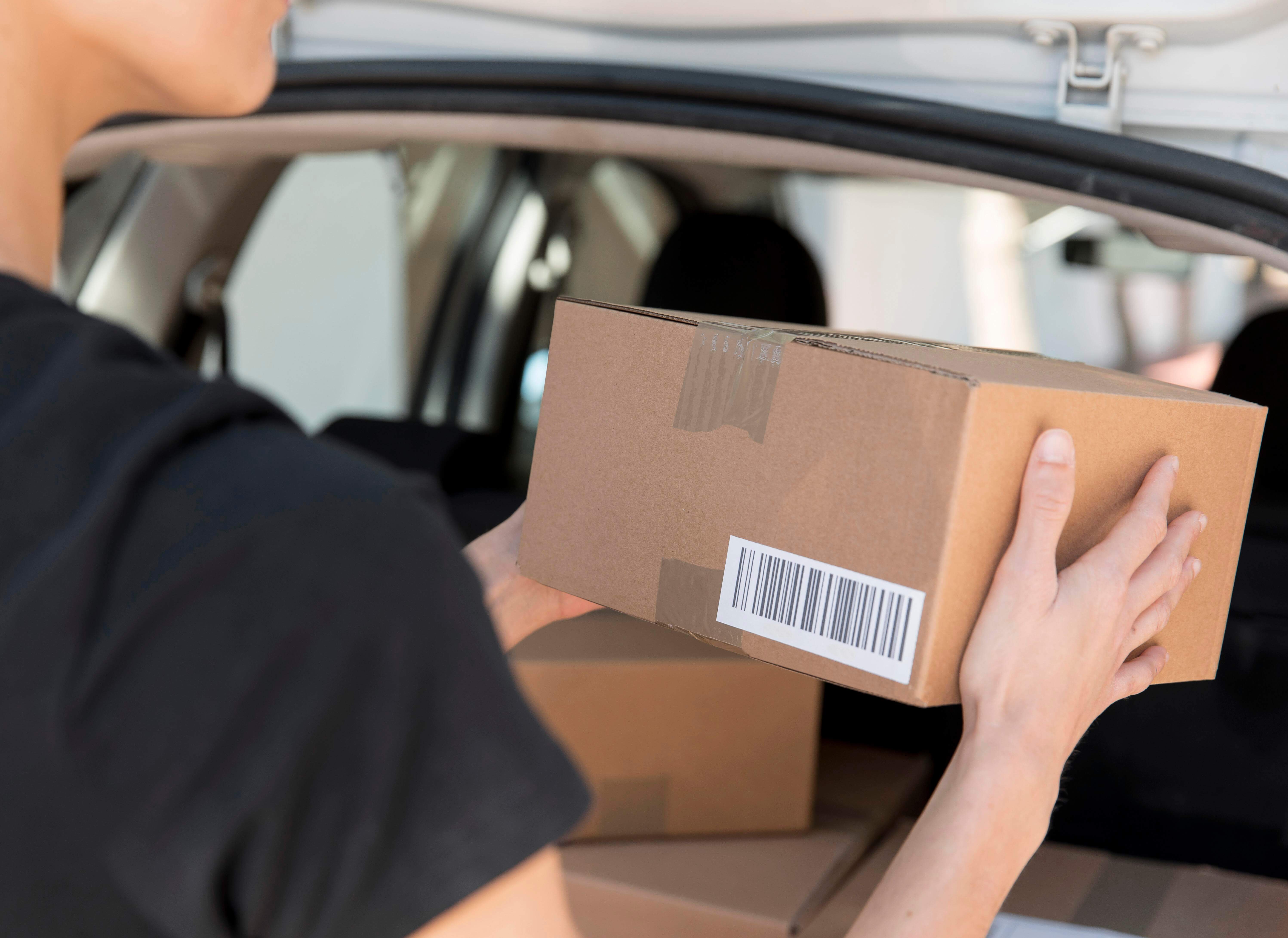 A close-up shot of a delivery woman holding a package.